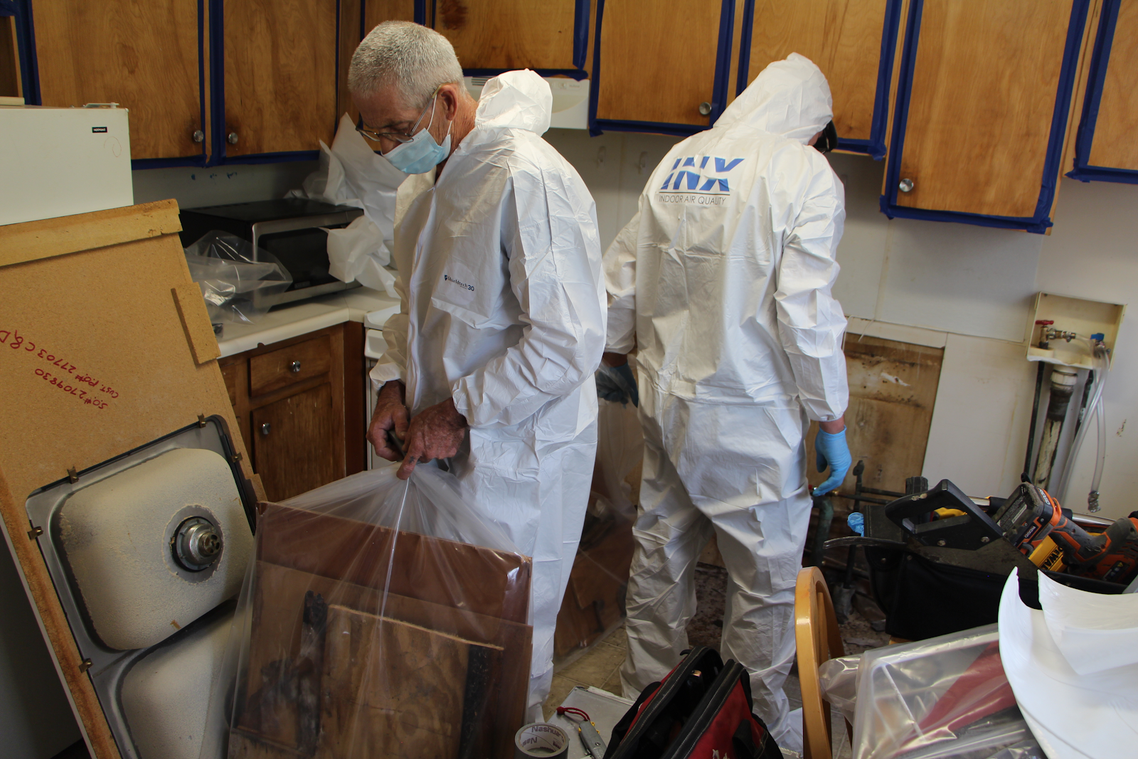 INX Indoor Air Quality mold removal technicians removing mold damaged materials in a kitchen 