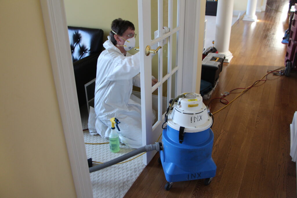 An INX mold technician using a HEPA vacuumin a  mold remediation historic homes project